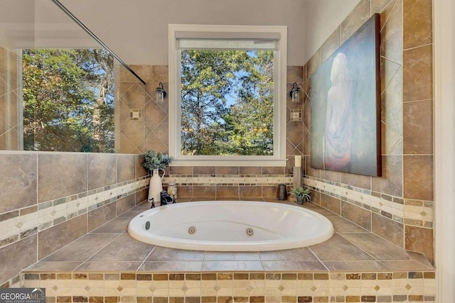 bathroom featuring a relaxing tiled tub and plenty of natural light