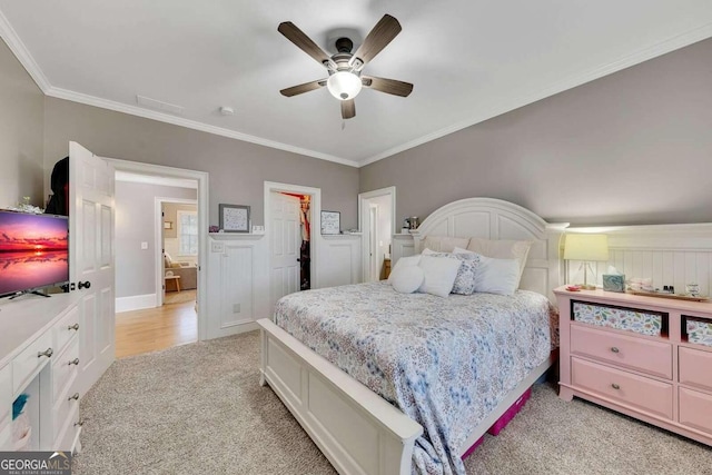 carpeted bedroom with ceiling fan and ornamental molding