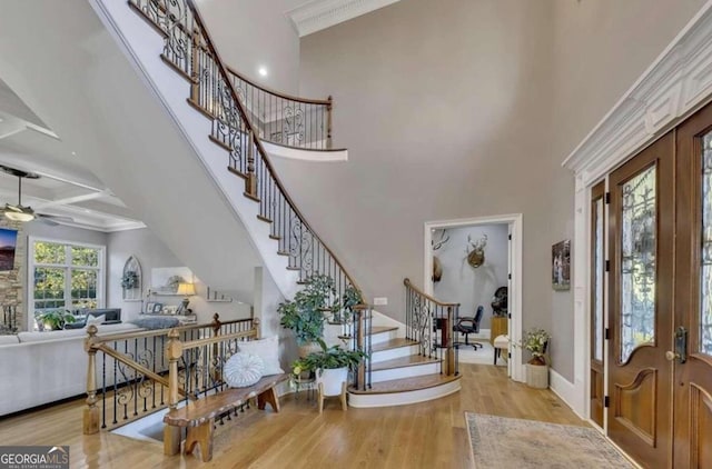 entrance foyer featuring a towering ceiling, light hardwood / wood-style flooring, and french doors