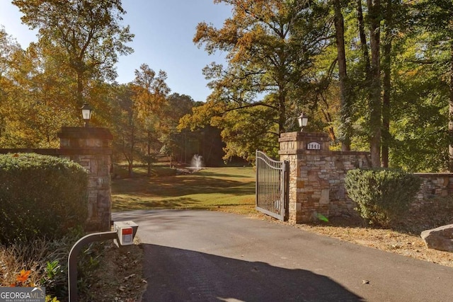 view of gate with a lawn