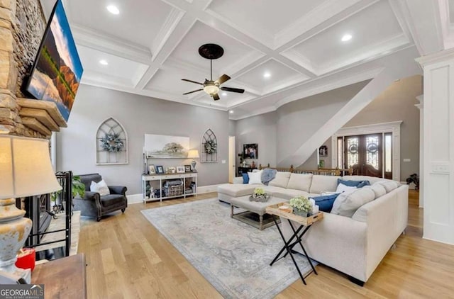 living room with coffered ceiling, crown molding, light hardwood / wood-style flooring, and beam ceiling