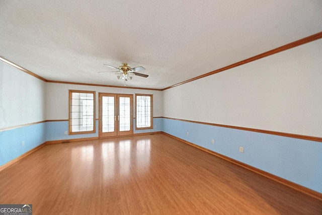 spare room featuring hardwood / wood-style floors, crown molding, and french doors