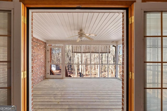 unfurnished sunroom featuring plenty of natural light and ceiling fan