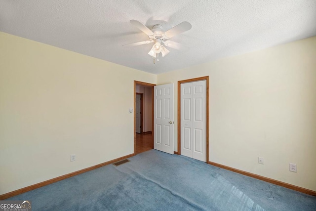 carpeted spare room with ceiling fan and a textured ceiling