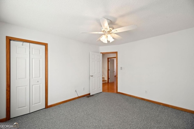 unfurnished bedroom with ceiling fan, a closet, a textured ceiling, and carpet