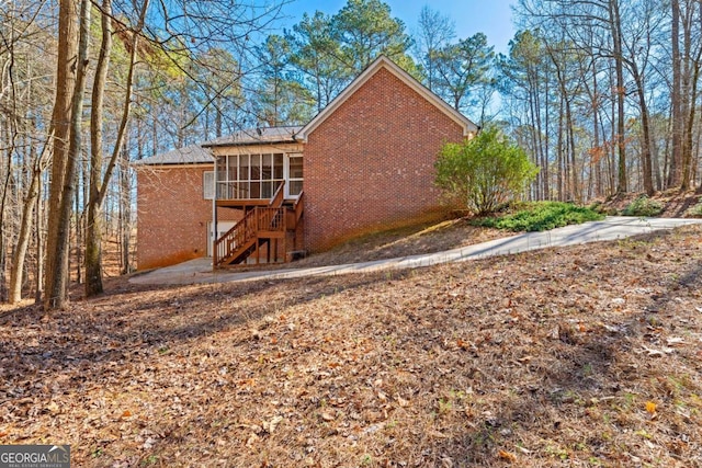 rear view of house featuring a sunroom