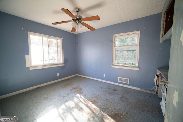 carpeted spare room featuring ceiling fan