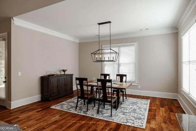 dining area with ornamental molding, plenty of natural light, and dark wood-type flooring