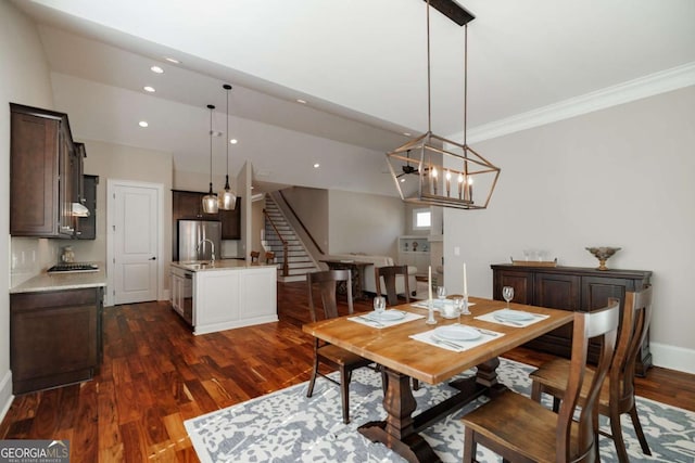 dining space featuring dark hardwood / wood-style flooring, crown molding, and an inviting chandelier