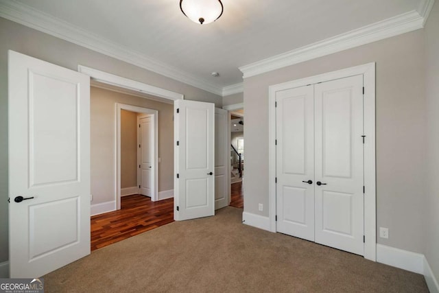 unfurnished bedroom featuring crown molding, a closet, and carpet