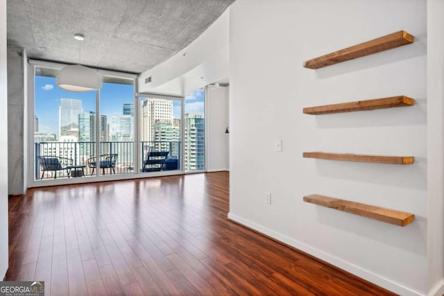 spare room featuring hardwood / wood-style floors and a wall of windows