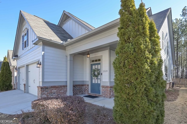 view of front of house with an attached garage, brick siding, board and batten siding, and driveway