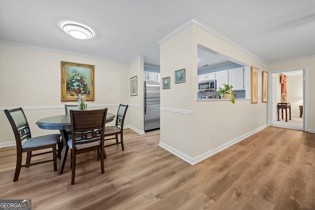 dining room featuring ornamental molding and light wood-type flooring