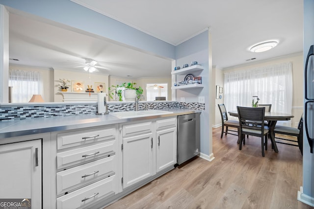 kitchen with sink, white cabinets, stainless steel dishwasher, light hardwood / wood-style floors, and crown molding