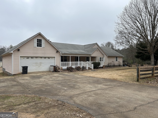 view of front facade featuring driveway, a garage, and a porch