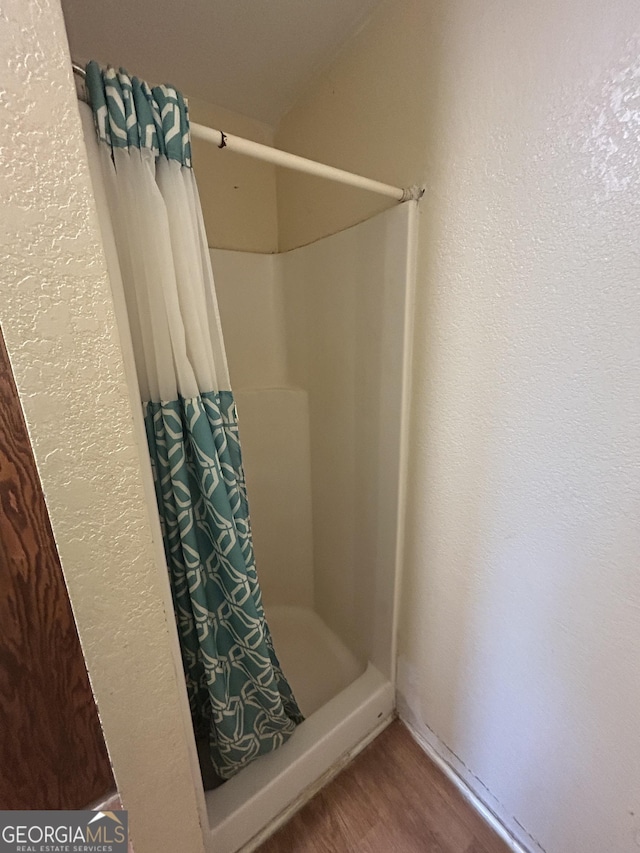 bathroom featuring a stall shower and wood finished floors