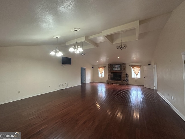 unfurnished living room featuring an inviting chandelier, high vaulted ceiling, a fireplace, dark wood-type flooring, and a textured ceiling