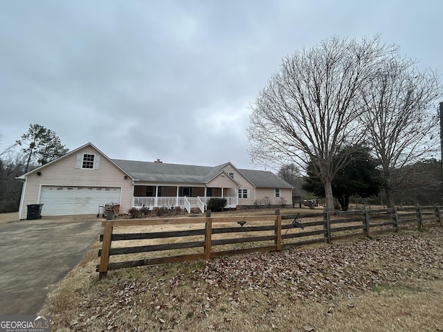 ranch-style house with covered porch, aphalt driveway, and fence