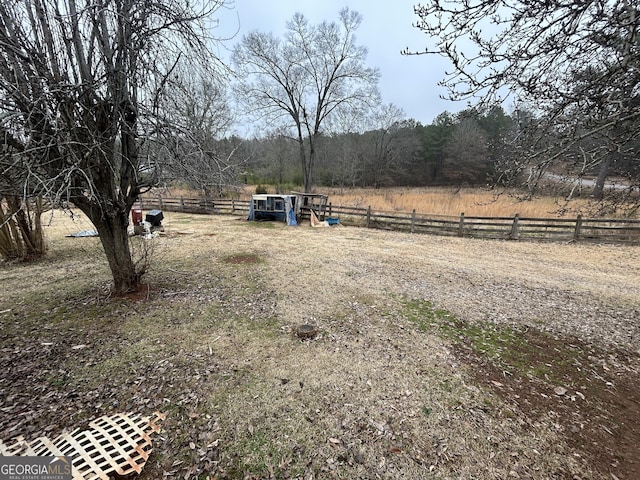 view of yard featuring a rural view and fence