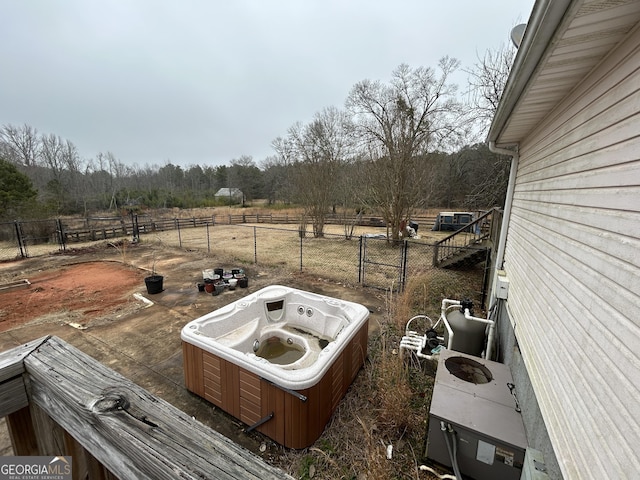 view of patio with fence and a hot tub