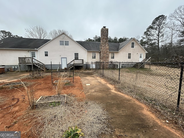 382 Lower Lovelace Rd, West Point, GA 31833 - back of house with a vegetable garden, a chimney, a deck, and driveway