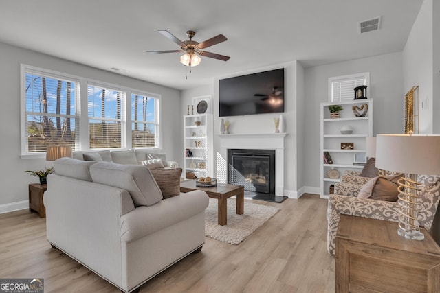 720 Lanarck Way, Peachtree City, GA 30269 - living room featuring a ceiling fan, a glass covered fireplace, and light wood finished floors