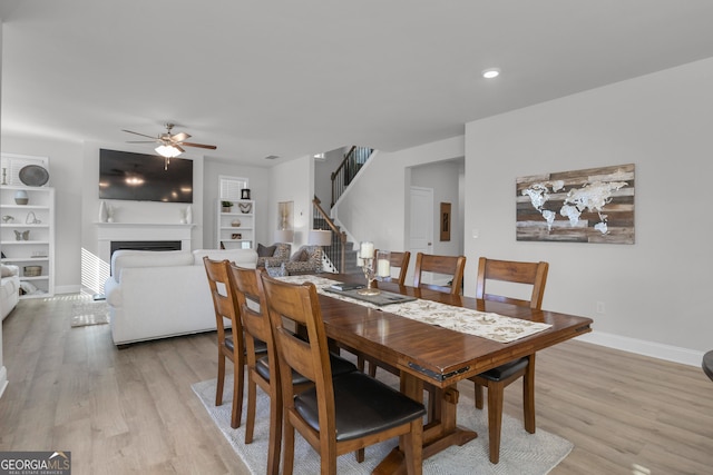 dining space with ceiling fan, built in features, and light hardwood / wood-style flooring