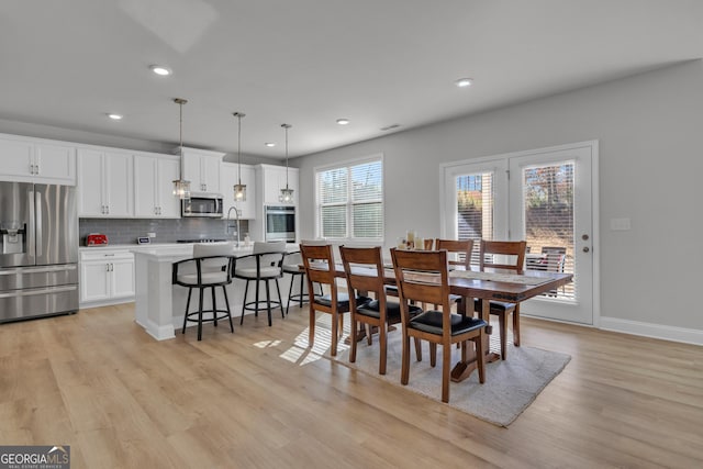 dining space with sink and light hardwood / wood-style floors