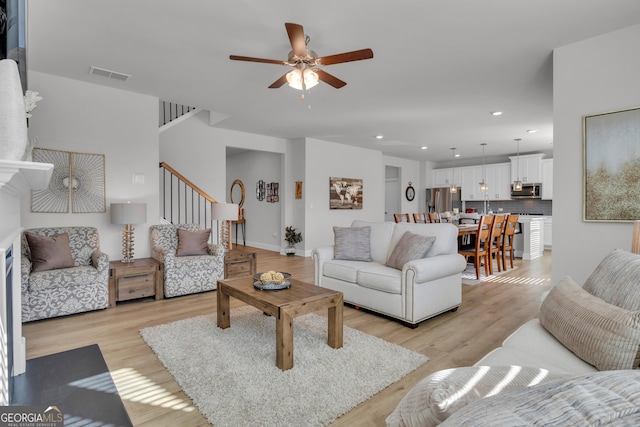 living room featuring light hardwood / wood-style flooring and ceiling fan