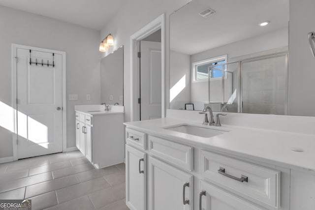 bathroom featuring vanity, a shower with door, and tile patterned floors