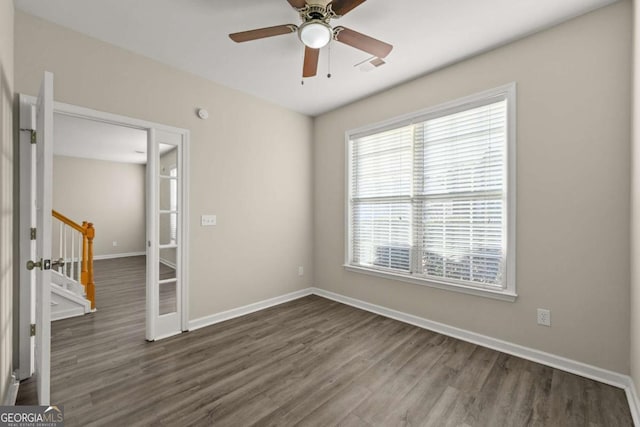 unfurnished room with dark wood-type flooring and ceiling fan