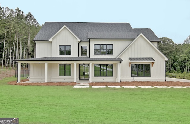 back of property with a yard and covered porch