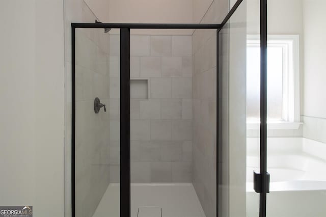 bathroom with an enclosed shower and plenty of natural light