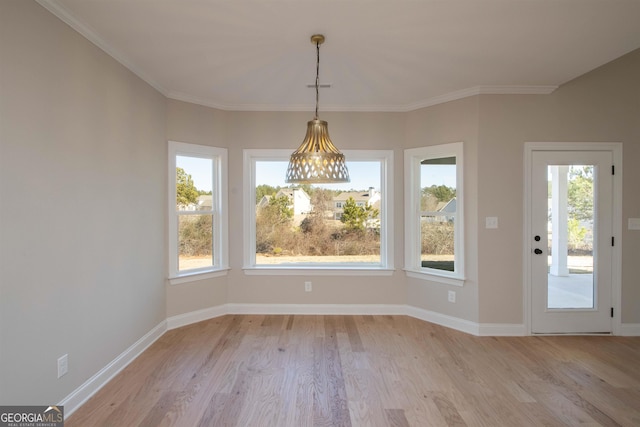 unfurnished dining area featuring ornamental molding, a healthy amount of sunlight, and light hardwood / wood-style flooring