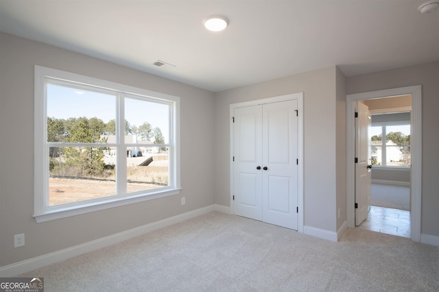 unfurnished bedroom with a closet and light carpet