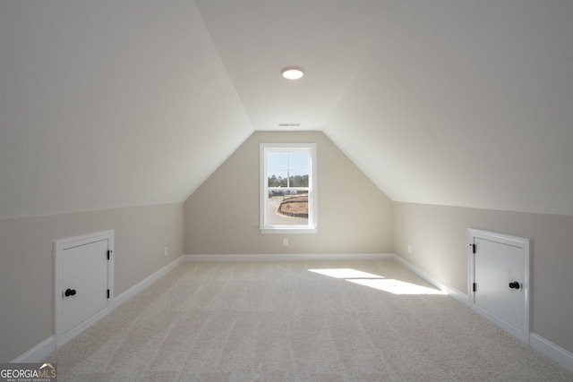 bonus room featuring light colored carpet and vaulted ceiling