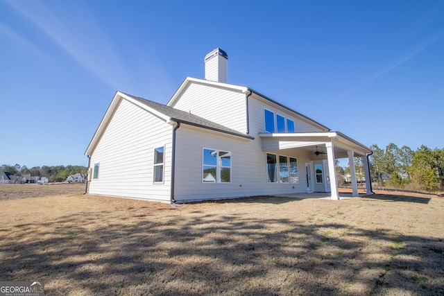 rear view of house with a patio area, ceiling fan, and a lawn