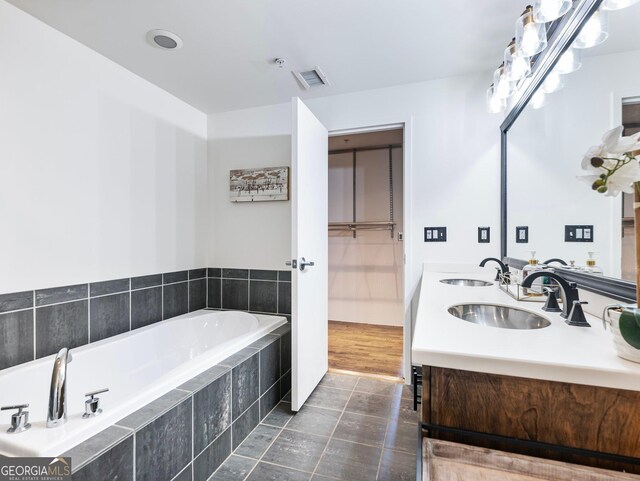 bathroom featuring vanity, tiled bath, and tile patterned floors