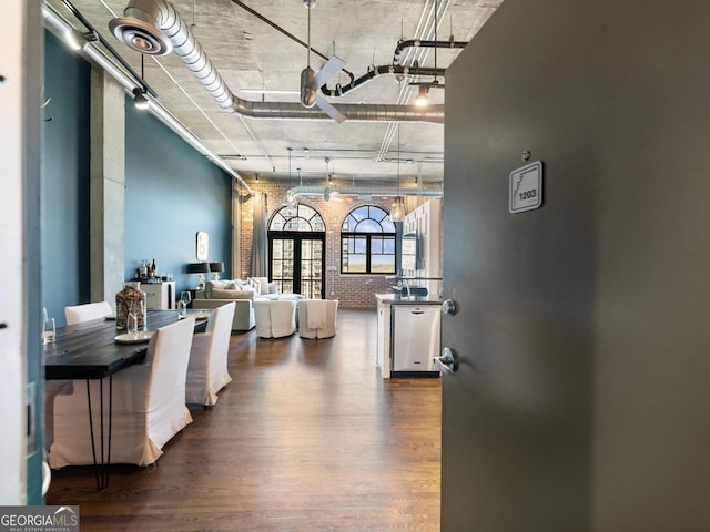 interior space featuring hardwood / wood-style flooring and brick wall