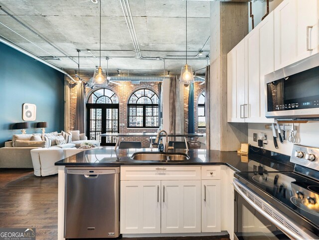 kitchen featuring white cabinetry, stainless steel appliances, sink, and pendant lighting