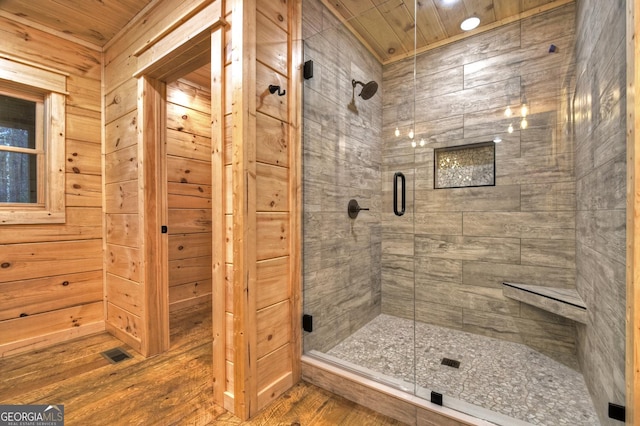 bathroom featuring wood-type flooring, wooden ceiling, an enclosed shower, and wood walls