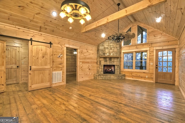 unfurnished living room featuring hardwood / wood-style flooring, wooden walls, and beam ceiling