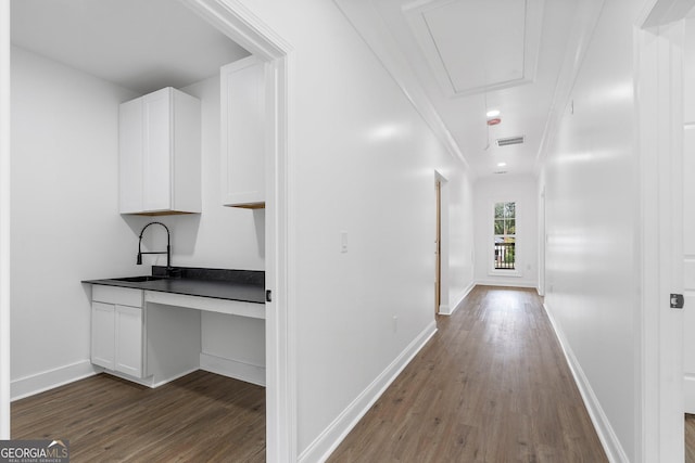 hallway featuring crown molding, wood-type flooring, and sink