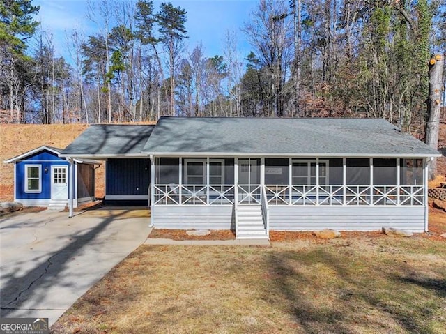 ranch-style house with a sunroom and a front yard