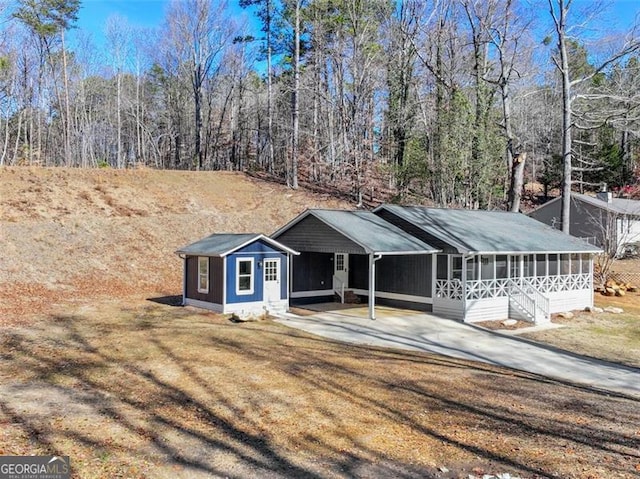 ranch-style home featuring a front lawn, a carport, and a sunroom