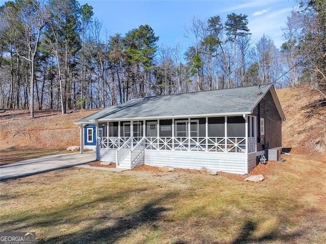 view of front of house featuring a front lawn and a sunroom