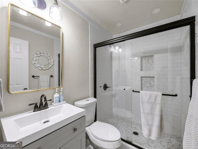 bathroom with vanity, toilet, and an enclosed shower