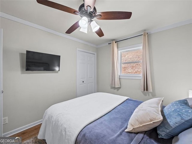 bedroom with hardwood / wood-style floors, crown molding, and ceiling fan