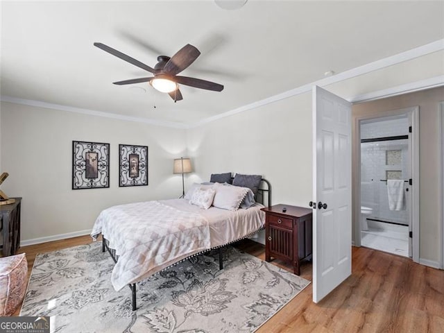 bedroom featuring hardwood / wood-style flooring, ornamental molding, ceiling fan, and ensuite bathroom