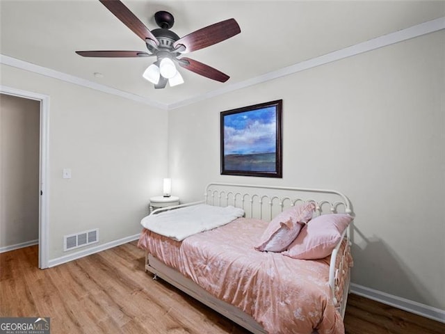 bedroom with light hardwood / wood-style flooring, ornamental molding, and ceiling fan